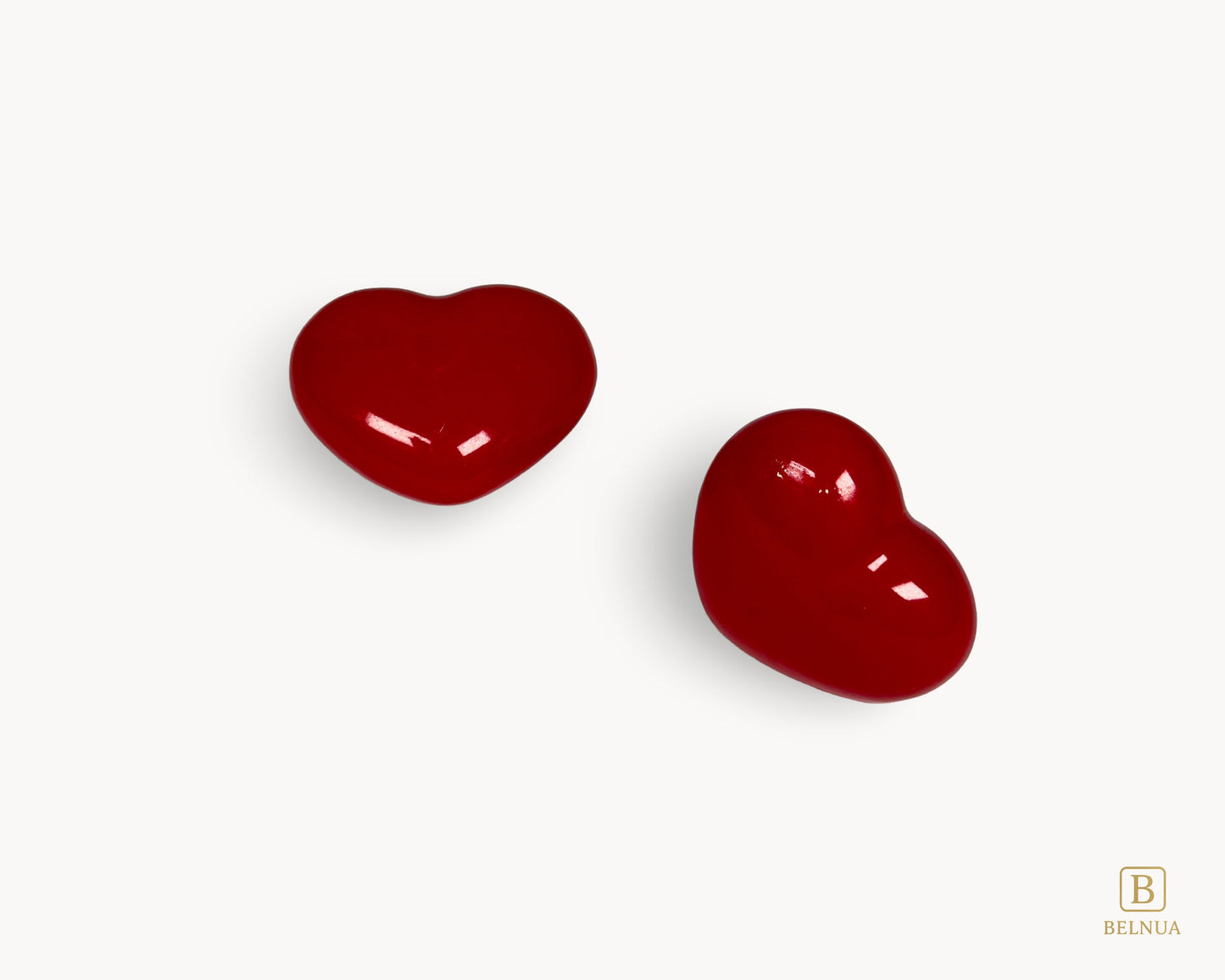 Styled pair of Belnua Veyla red porcelain heart knobs on light background