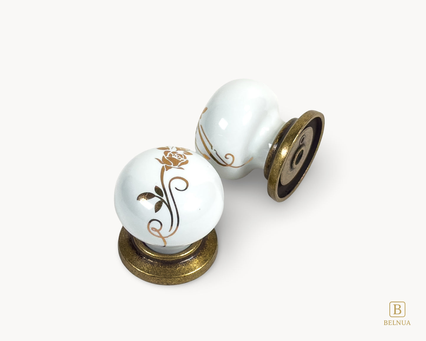 Belnua - Top and back flat lay view of ZERRA white ceramic/porcelain knob with golden scroll motif and antique brass base