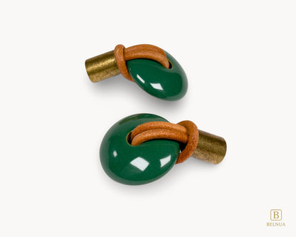 Rear angled perspective of the emerald green porcelain knob showing the textured antique brass mounting hardware.