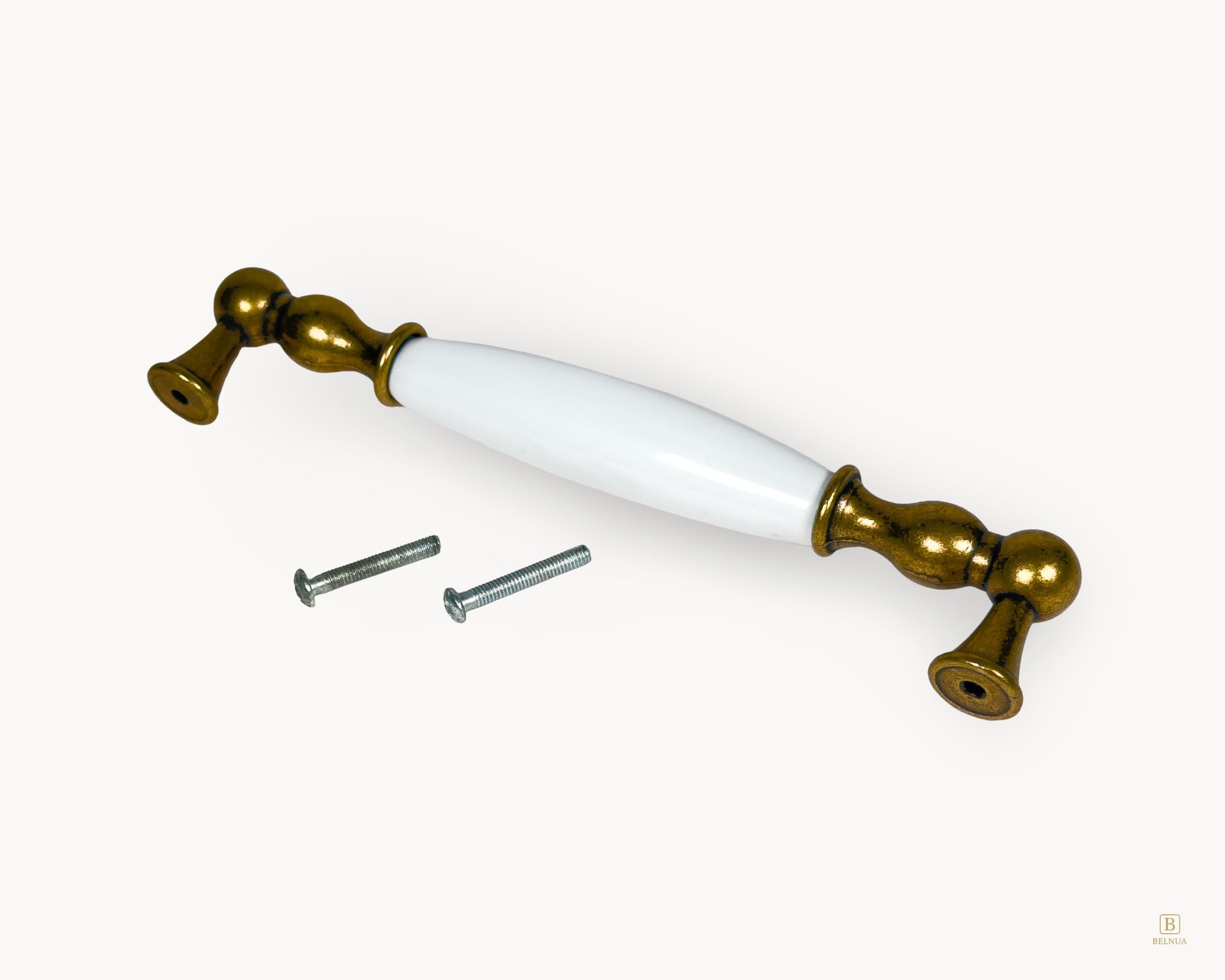Belnua Belmira 160mm antique brass handle showing white porcelain insert with golden scroll motif and fixing screws