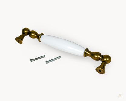 Belnua Belmira 160mm antique brass handle showing white porcelain insert with golden scroll motif and fixing screws