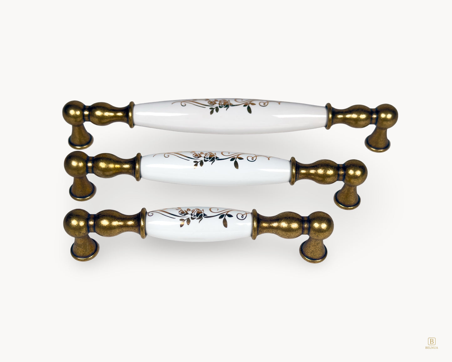 Belmira antique brass handle size comparison showing 128mm, 160mm and 192mm with white porcelain golden scroll design