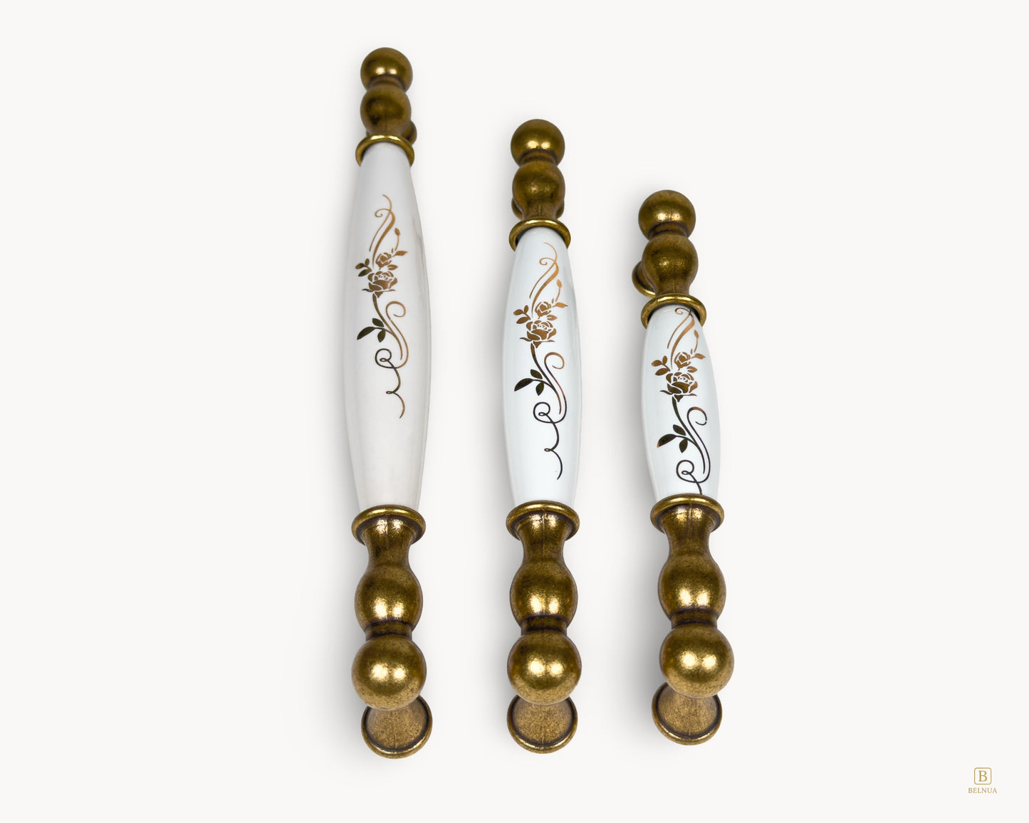 Vertical display of Belmira antique brass handles with white porcelain and golden scroll decoration