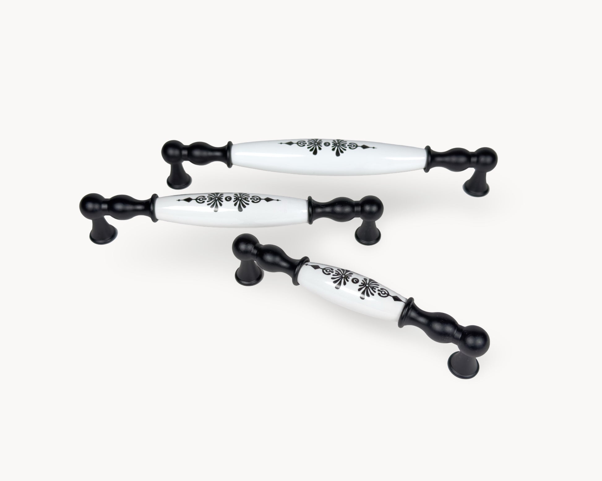 Angled view of Belmira black handles with white porcelain and Midnight Blossom motif, showcasing multiple sizes together.