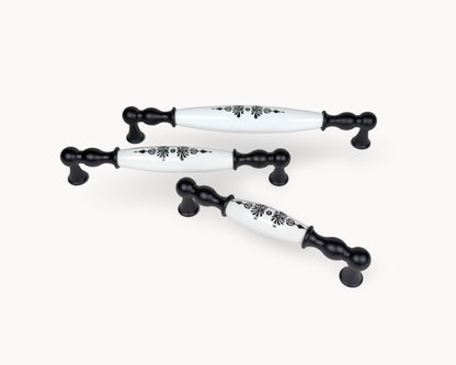 Angled view of Belmira black handles with white porcelain and Midnight Blossom motif, showcasing multiple sizes together.