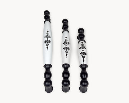 Flat lay image of Belmira black porcelain handles featuring the Midnight Blossom motif in three sizes.