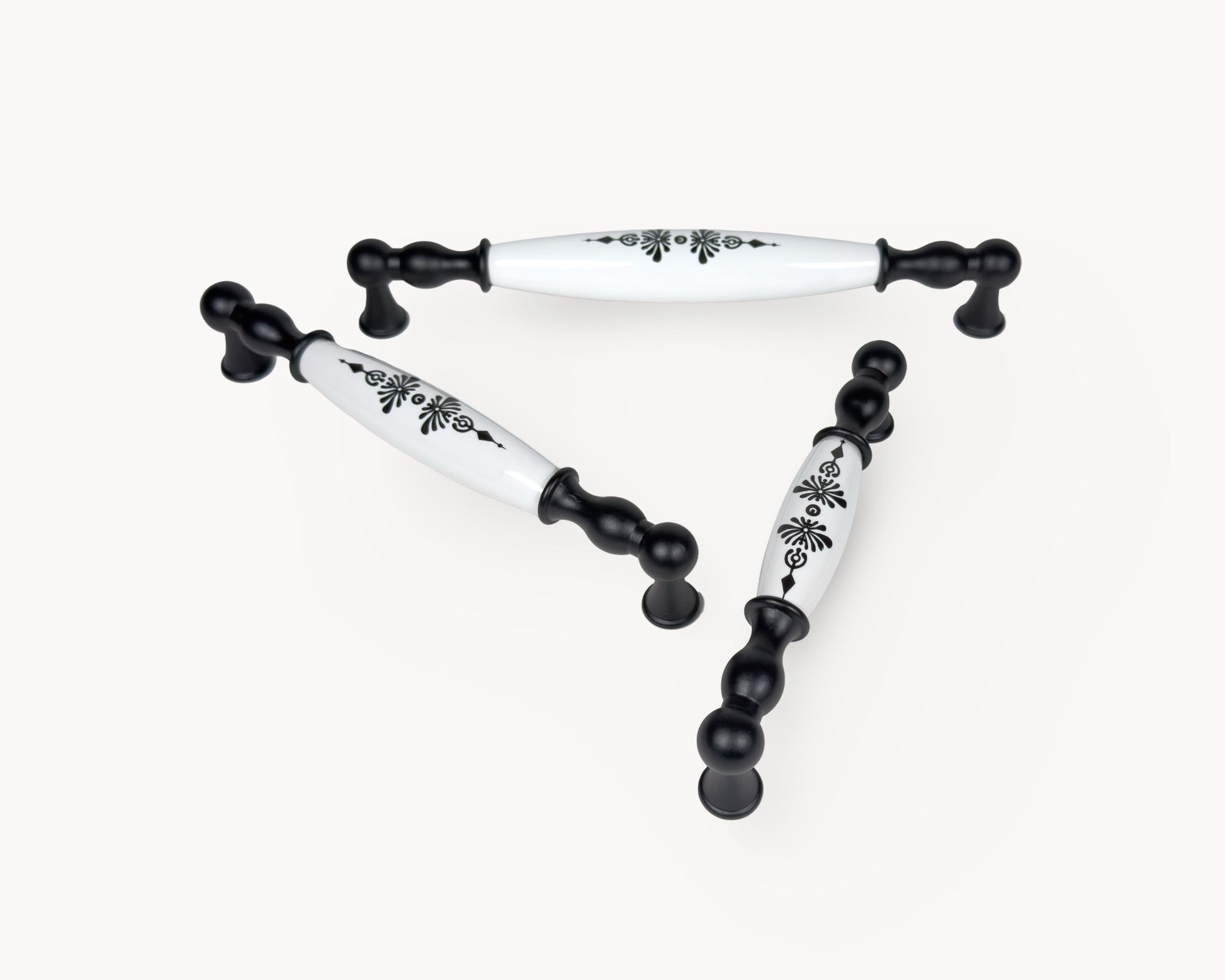 Perspective view of Belmira black porcelain handles displaying the Midnight Blossom motif across multiple sizes.
