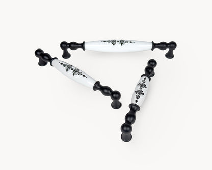 Perspective view of Belmira black porcelain handles displaying the Midnight Blossom motif across multiple sizes.