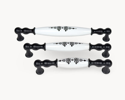 Styled group image of Belmira black cabinet handles with white porcelain and Midnight Blossom pattern.