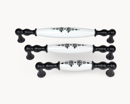 Styled group image of Belmira black cabinet handles with white porcelain and Midnight Blossom pattern.