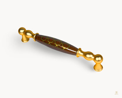 Angled view of Belnua Belmira 160mm gold cabinet handle with patterned porcelain insert