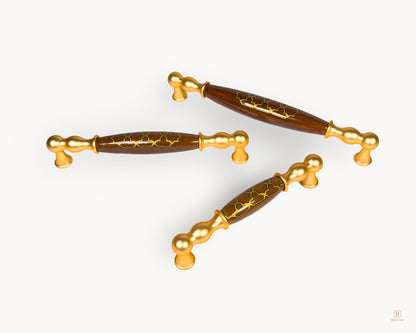 Belmira gold cabinet handle collection with dark brown porcelain inserts and Golden Tile design, shown in mixed sizes