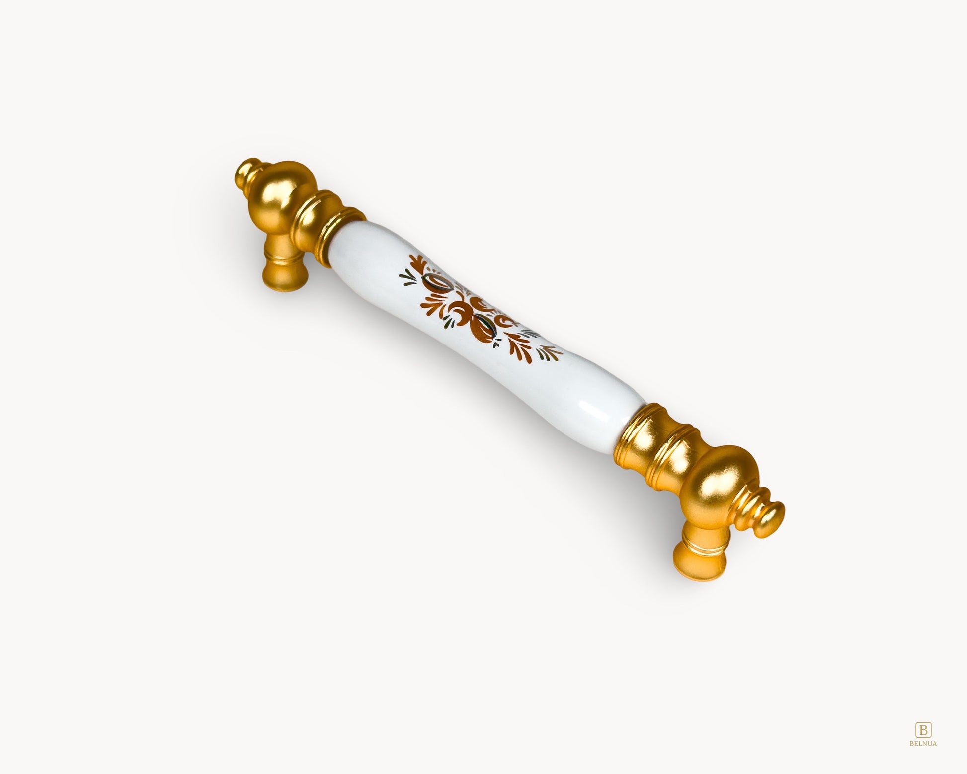 Angled view of Eloura 128mm gold handle with white porcelain insert and Golden Arch Bloom motif for cabinet and drawer use
