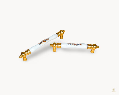 Eloura gold kitchen handle with white porcelain insert and Golden Arch Bloom motif shown in detailed perspective angle