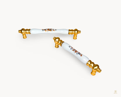 Luxury Eloura gold handles with white porcelain and Golden Arch Bloom pattern, styled composition for kitchen cabinetry
