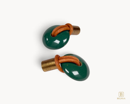 Side installation view of an emerald green porcelain knob illustrating the projection of the antique brass fixings.