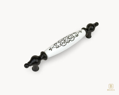 Angled view of Lumora porcelain cabinet handle 128mm with black metal base