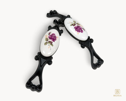 Belnua - Top angled of Nureya cabinet pull handle with black metal base featuring rose motif on white ceramic/porcelain