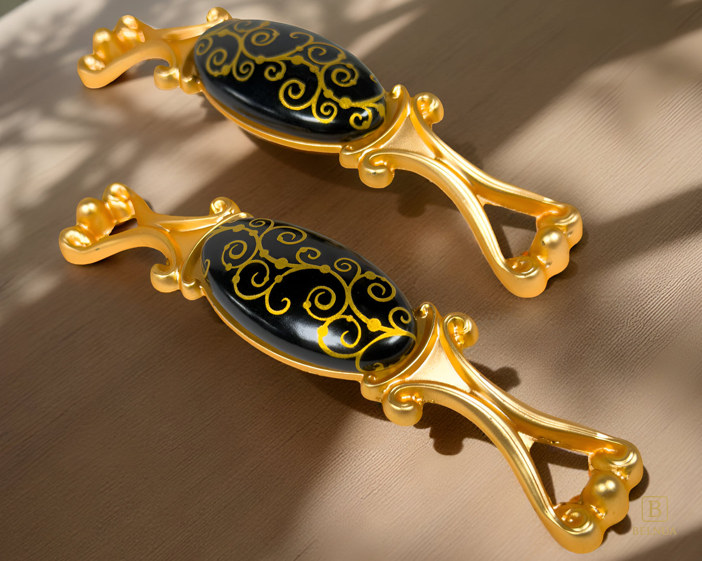 Belnua- Two decorative Nureya pulls with gold frames and black porcelain with golden scroll motif with beige background with shadows
