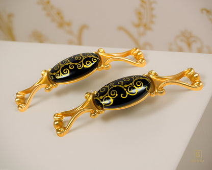 Belnua- Two decorative Nureya pulls with gold frames and black porcelain with golden scroll motif with marble and floral background