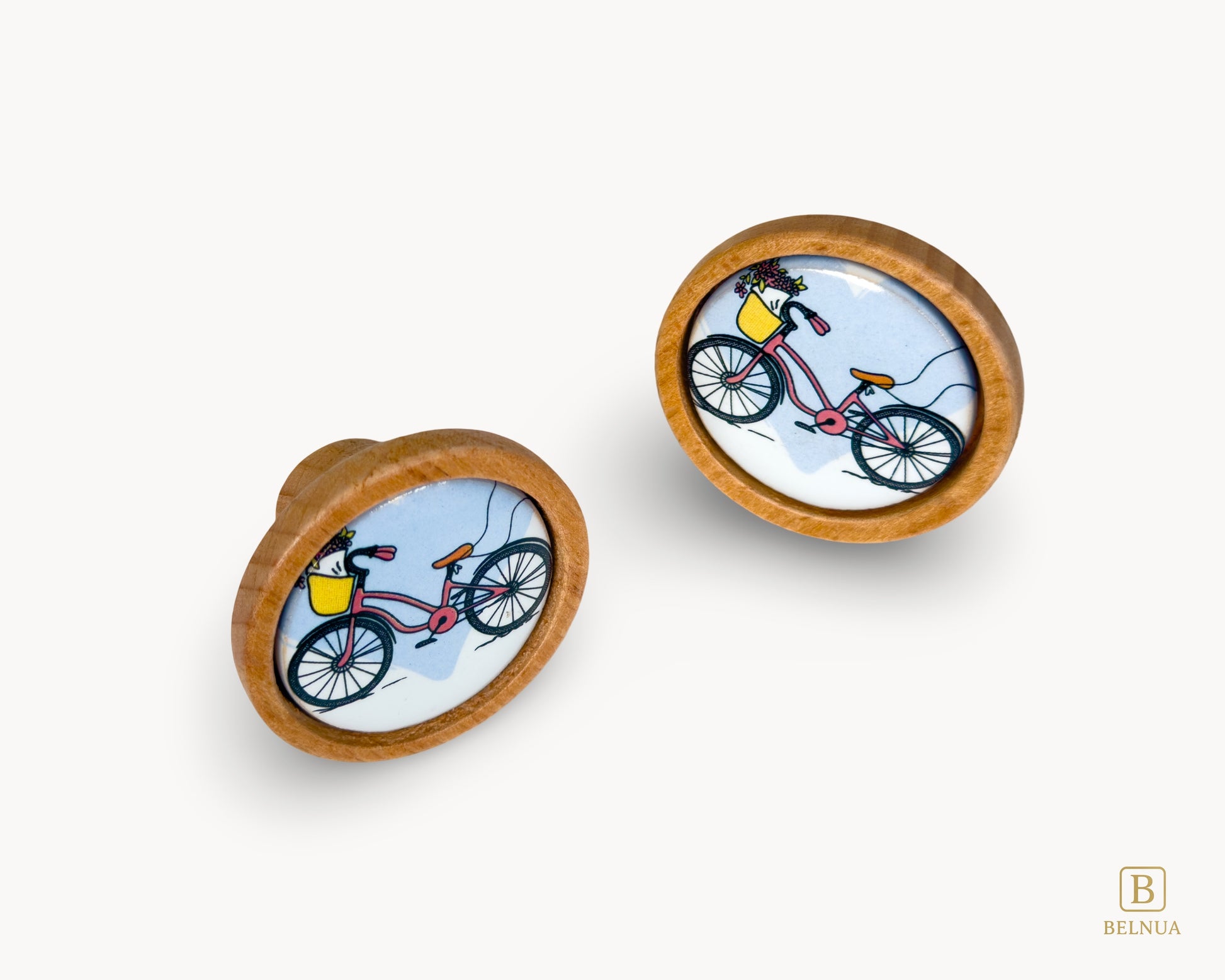 Belnua - Front angled view of luxury Nuvino children knob pair with oak wood base and bicycle design porcelain insert for boys, girls, nursery, teens room and furniture