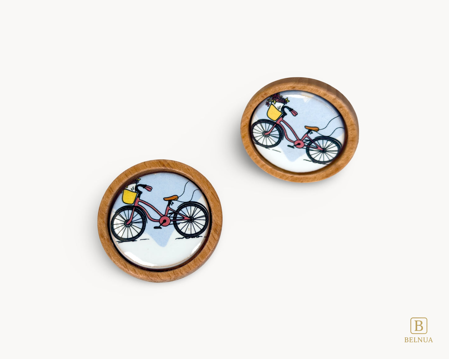 Belnua - Front angled and top view of delicate Nuvino children knob pair with natural oak wood base and bicycle design porcelain insert for boys, girls, nursery, teens room and furniture