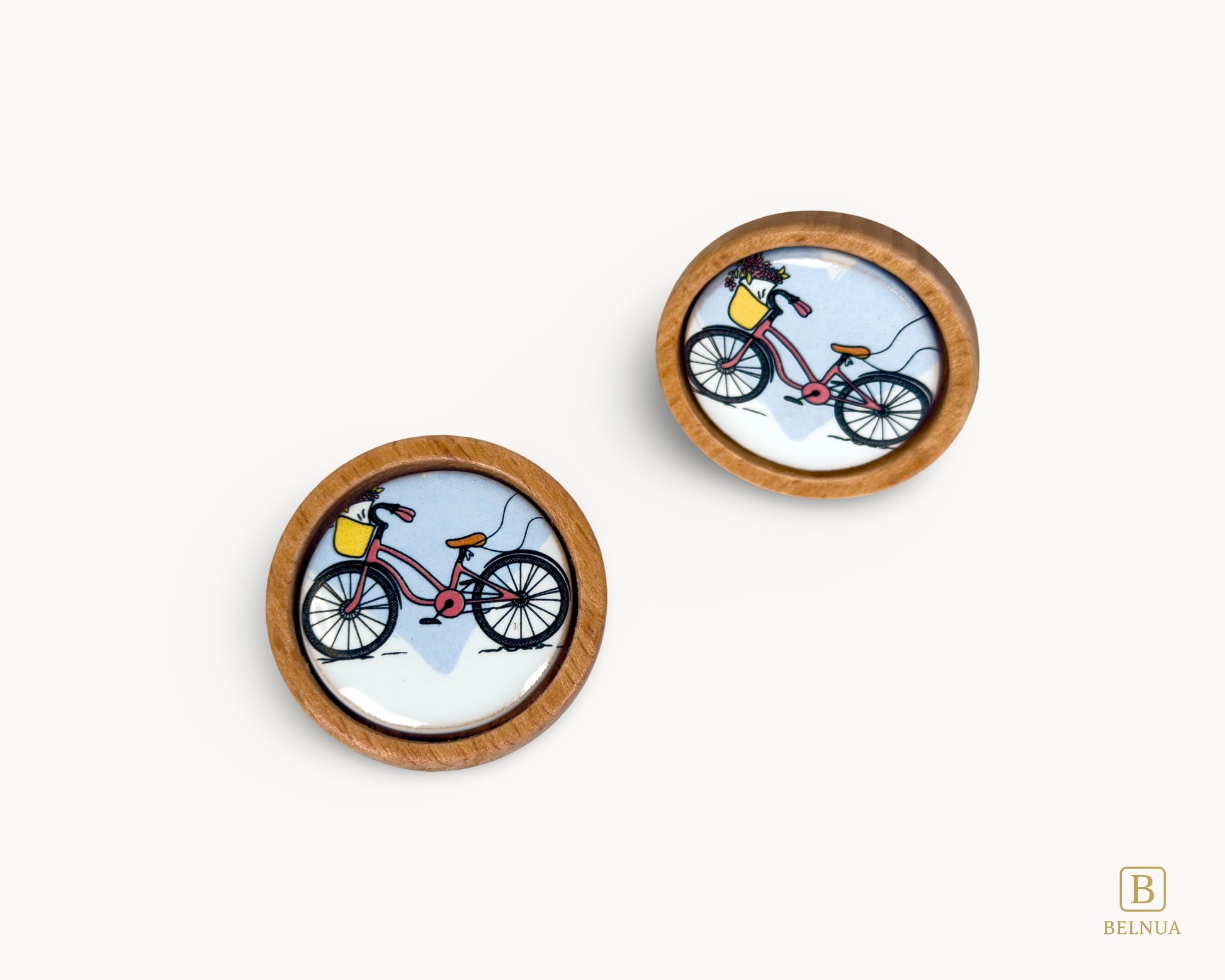 Belnua - Front angled and top view of delicate Nuvino children knob pair with natural oak wood base and bicycle design porcelain insert for boys, girls, nursery, teens room and furniture