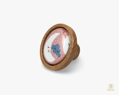 Belnua - Front left angled view of delicate Nuvino children knob with oak wood base and moon&star motif porcelain for nursery, children, teens, girls room and furniture