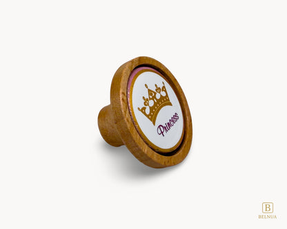 Belnua - Right angled view of Nuvino oak wood knob with porcelain/ceramic insert with princes crown design for girls, children, nursery and teen rooms