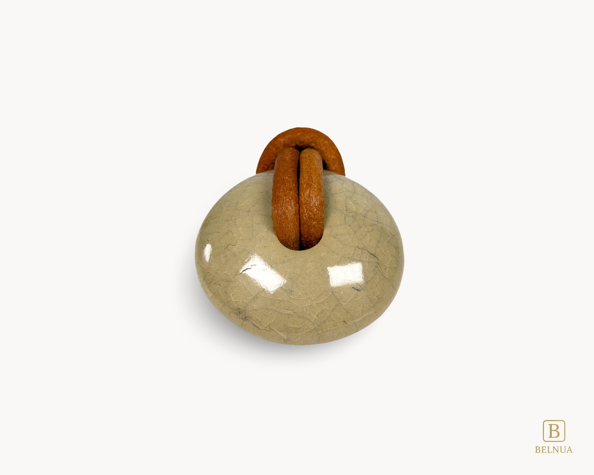 Front-centred view of REVINA porcelain cabinet knob with crackle glaze, leather loop and antique brass base