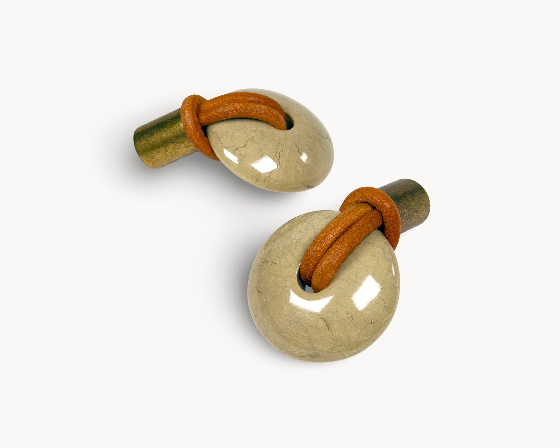 Side view of REVINA porcelain knob showing antique brass stem and leather loop detail
