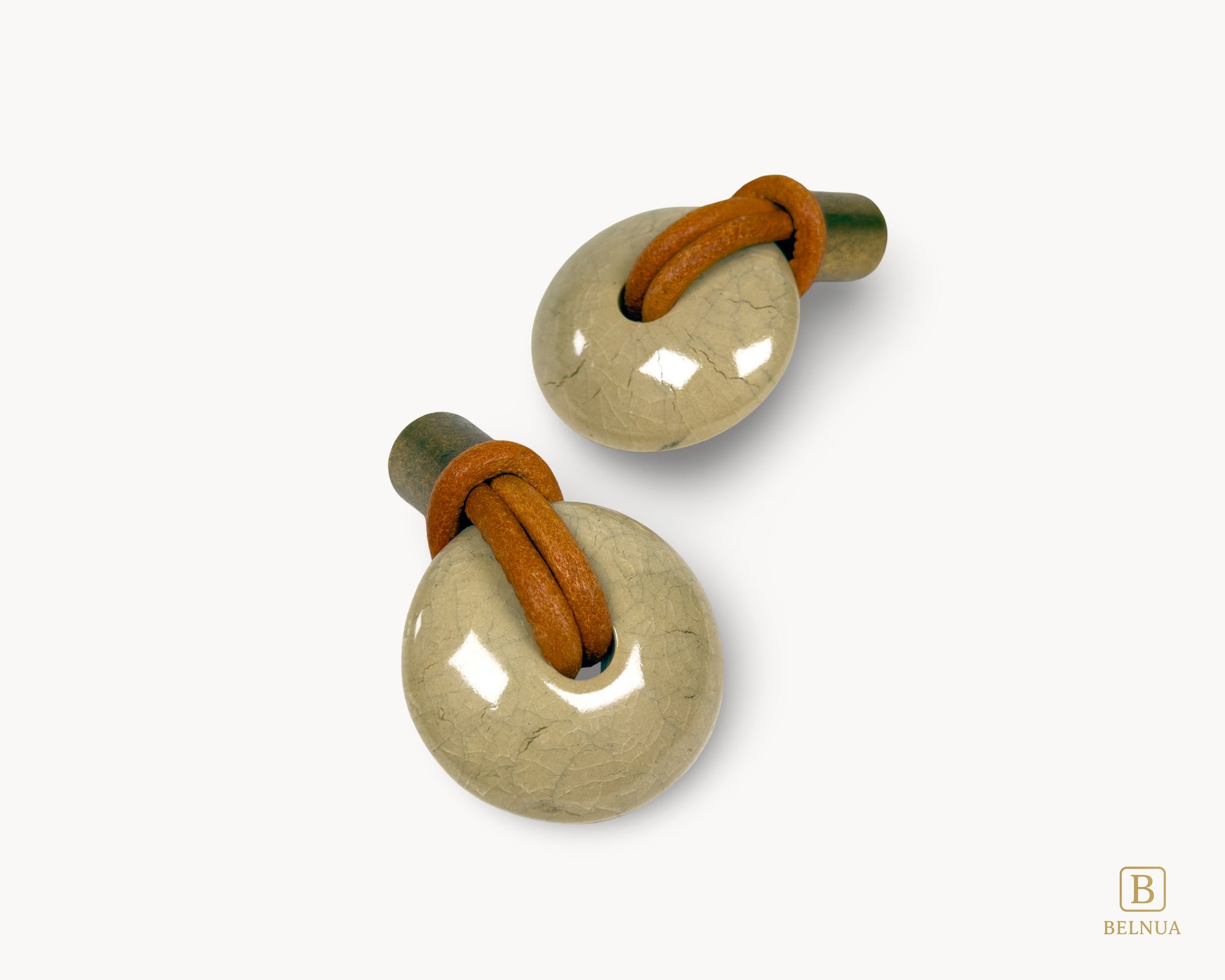 Close-up of brown leather loop wrapped through porcelain knob with antique brass base