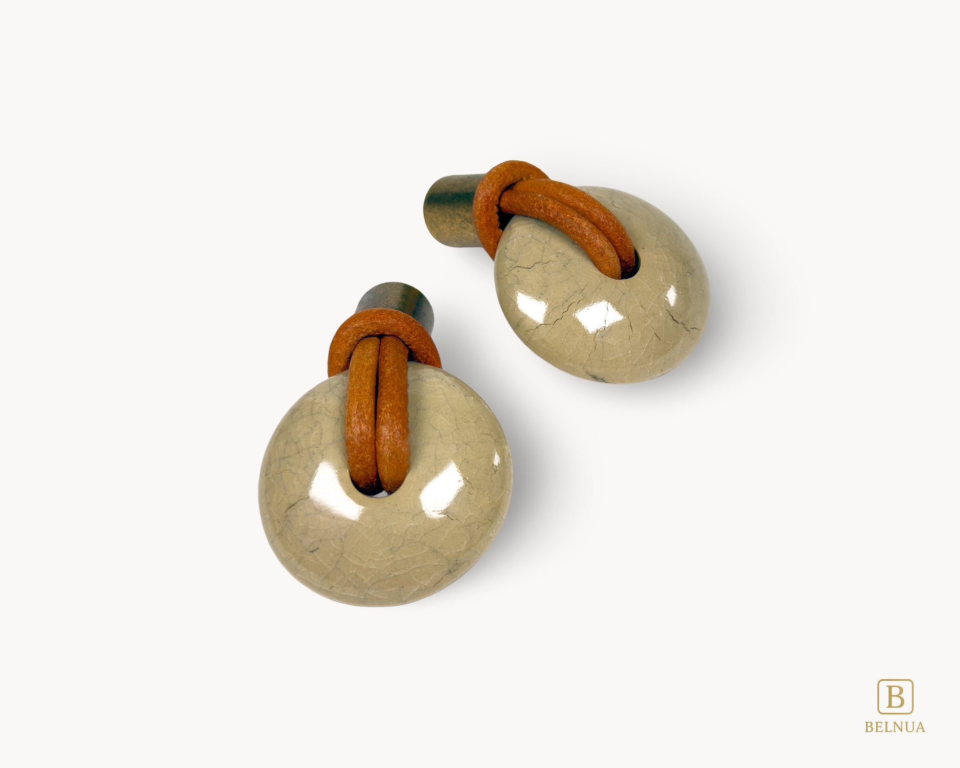Top view of REVINA porcelain knob showing leather loop threading through ceramic body