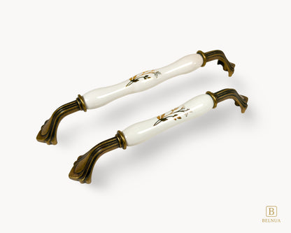 Belnua - Left angled view of Rosmira antique brass handle pair detailing earth brown floral motif with white ceramic/porcelain insert