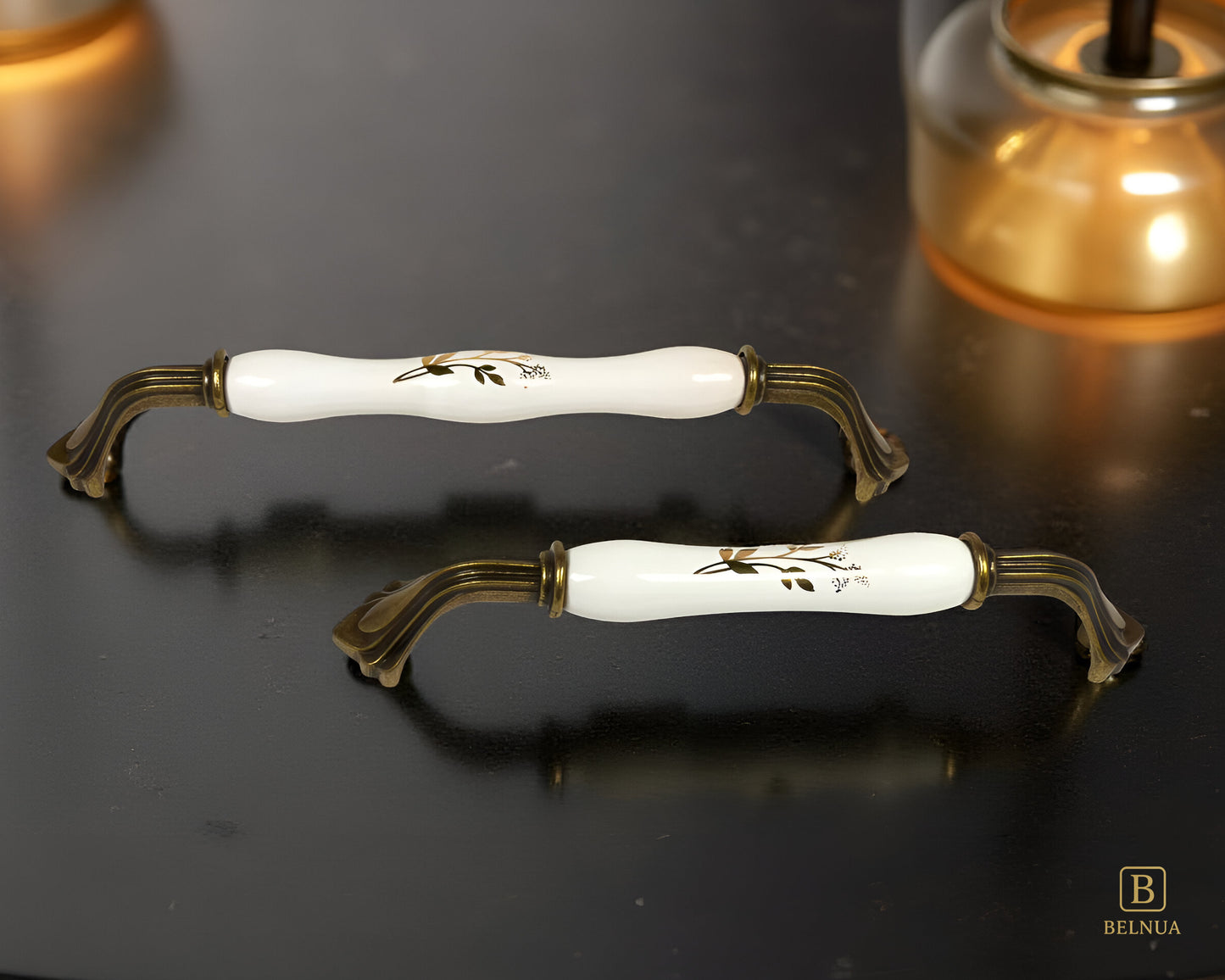 Belnua - ROSMIRA white porcelain/ceramic handle with earth motif and antique brass finish on black surface with light