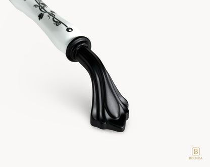 Belnua - Close up of Rosmira decorative matte black handle with black leaf motif on white porcelain