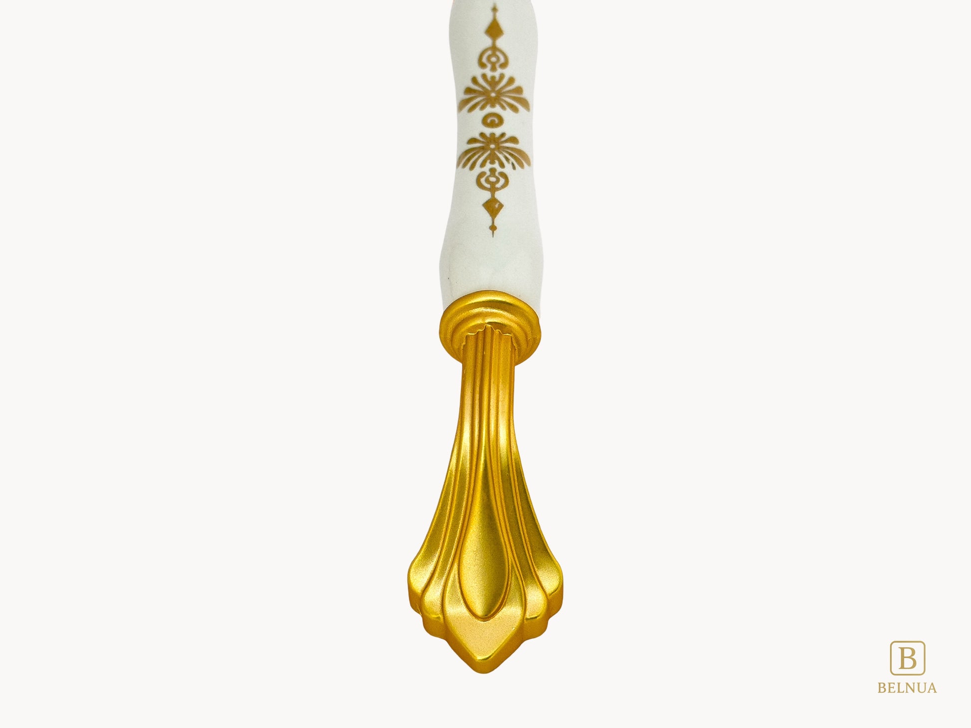 Belnua - Close up view of rosmira gold handle with white porcelain/ceramic featuring golden pattern 