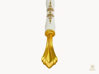 Belnua - Close up view of rosmira gold handle with white porcelain/ceramic featuring golden pattern 