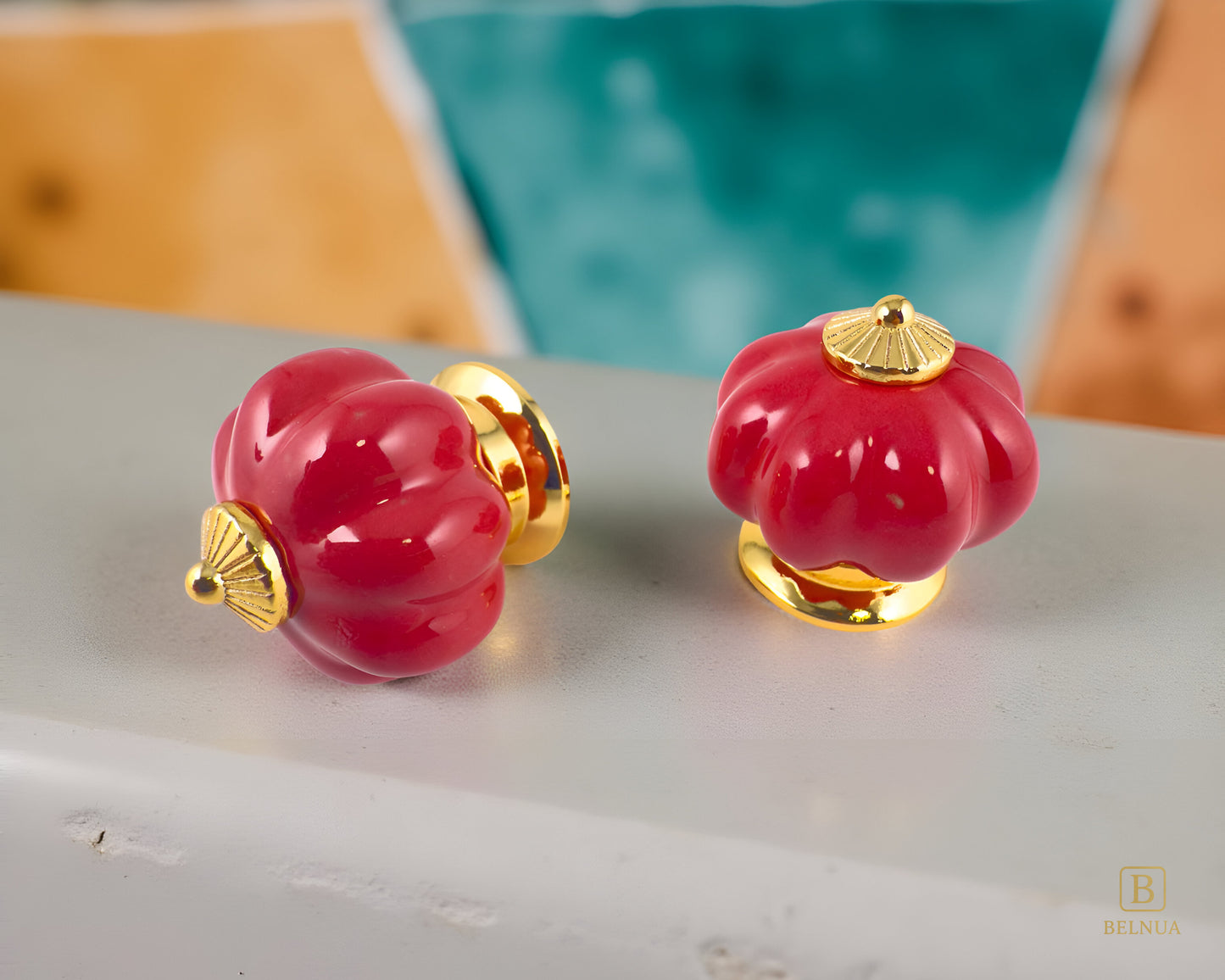 Belnua - Top and left side view of Tavira cabinet porcelain knob in red colour with gold metal base in pumpkin shape with pastoral background