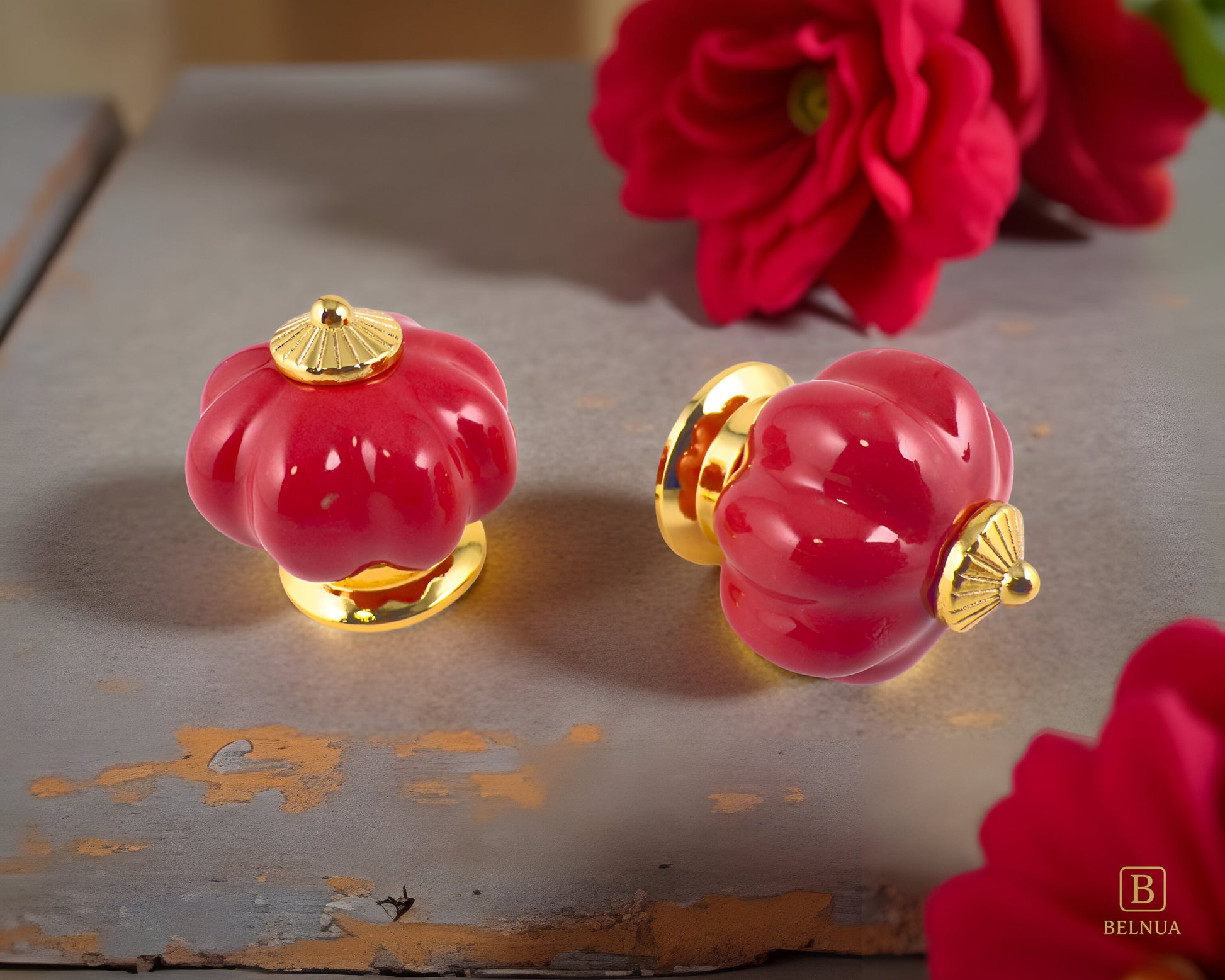 Belnua - Top and left front view of Tavira cabinet porcelain knob in red colour with gold metal base in pumpkin shape with floral rose background