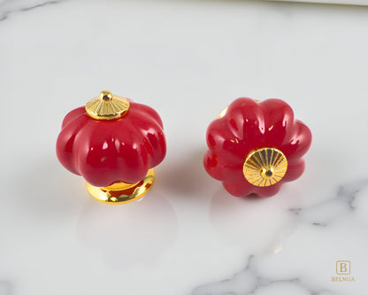 Belnua - Top and front view of Tavira cabinet porcelain knob in red colour with gold metal base in pumpkin shape with marble kitchen worktop