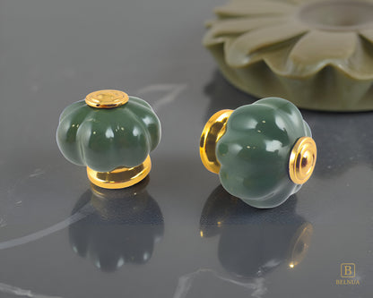 Belnua - Right front side and top view of Tavira dark green porcelain knob pair with gold base for cabinets on dark grey surface