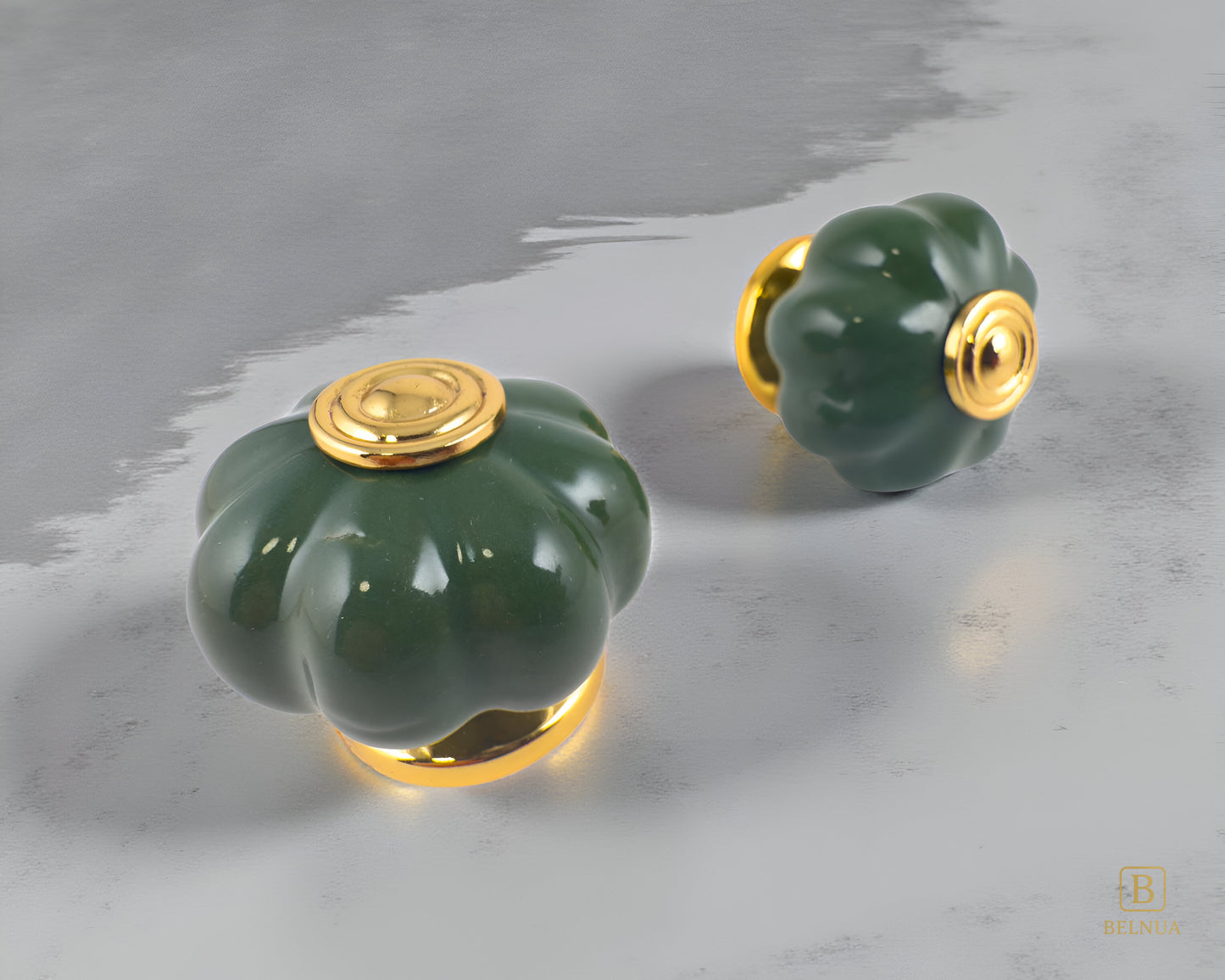 Belnua - Right and top view of Tavira dark green porcelain knob pair with gold base for cabinets on light grey surface