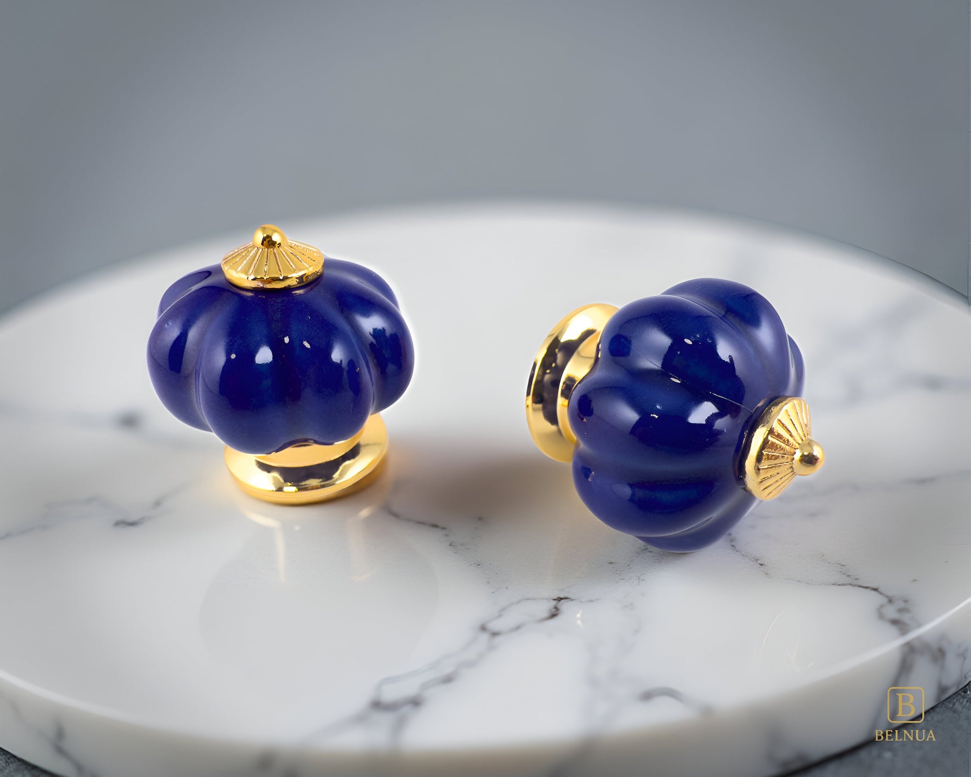 Belnua - Top and right side view of Tavira porcelain cabinet knob with cobalt colour in pumpkin design with gold metal base on marble plate