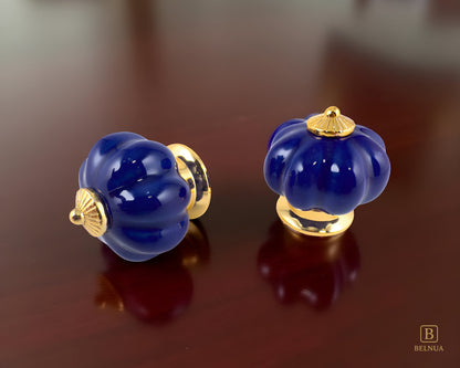 Belnua - Top and left side view of Tavira porcelain cabinet knob with cobalt colour in pumpkin design with gold metal base on on walnut surface