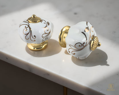 Belnua - Closeup view of luxury Tavira white porcelain cabinet knob pair with gold metal base on kitchen marble worktop