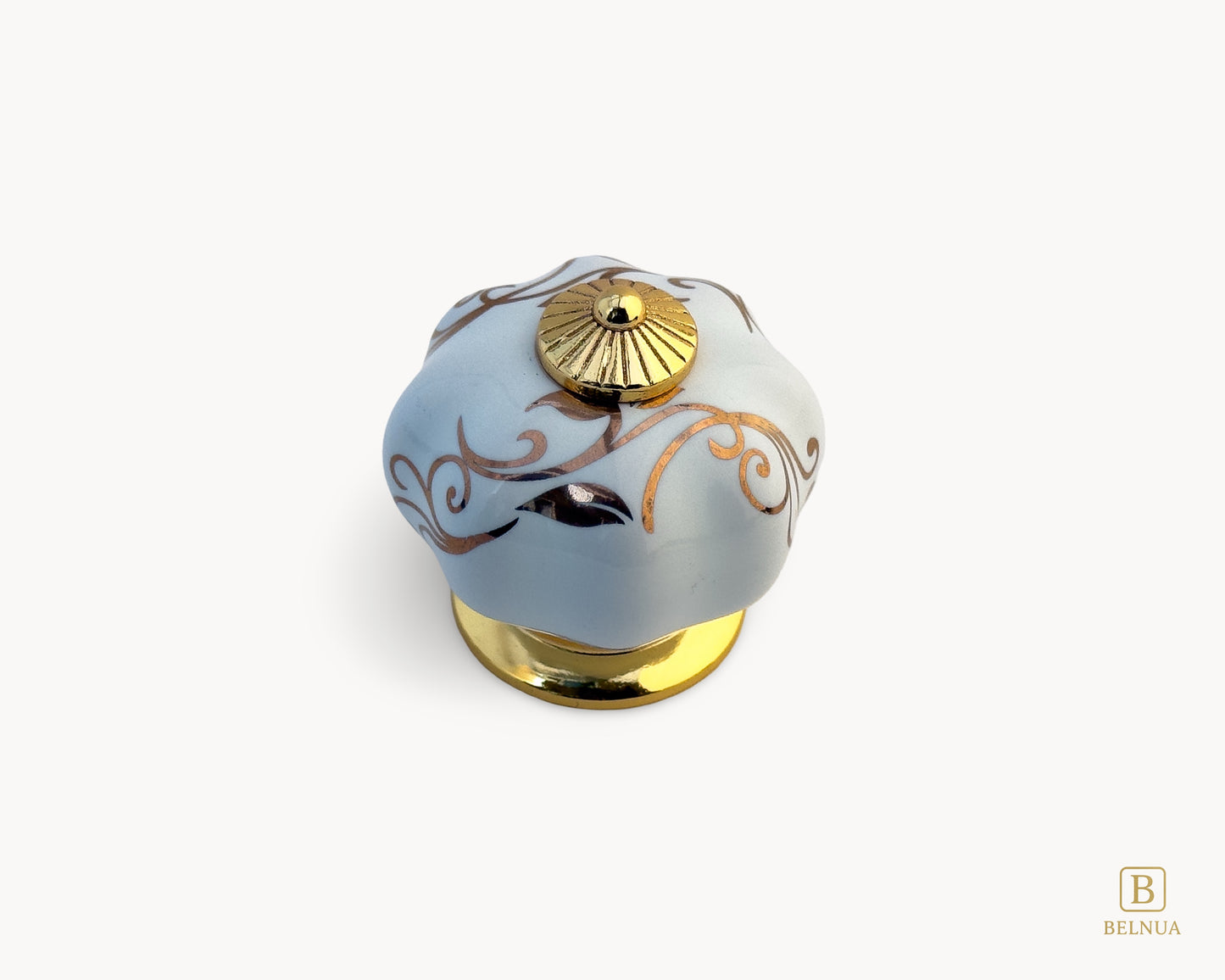 Belnua - Top view of Tavira white porcelain cabinet knob with delicate petal motif inserted on gold metal base.