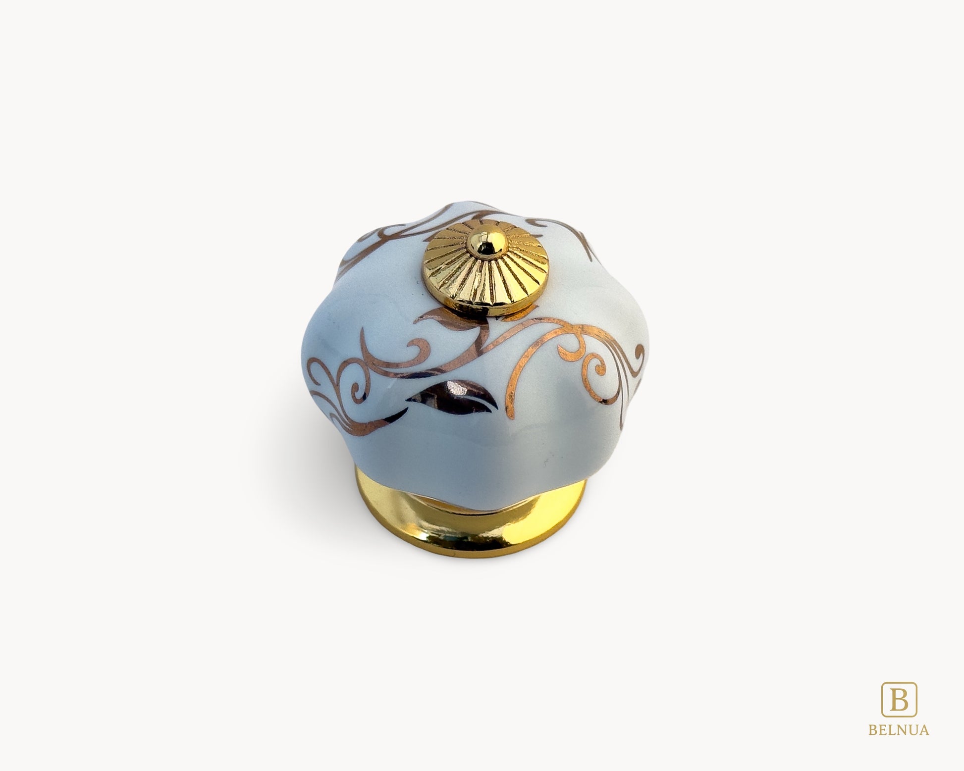 Belnua - Top view of Tavira white porcelain cabinet knob with delicate petal motif inserted on gold metal base.