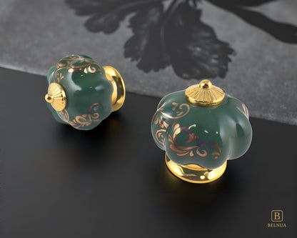 Belnua - Top and left view of luxury Tavira green porcelain cabinet knob with delicate golden vine cascade motif inserted gold metal base featuring on black leaf surface