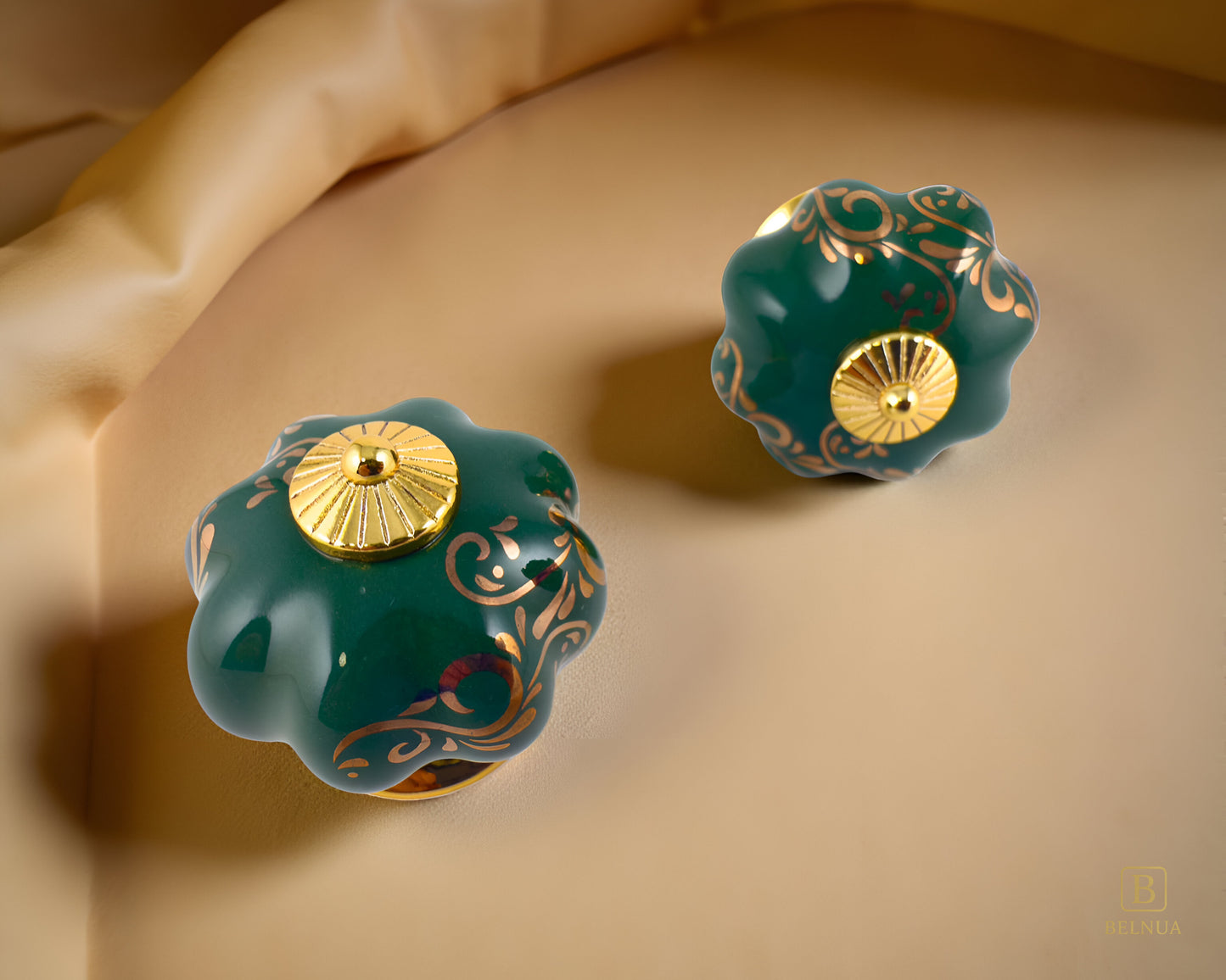 Belnua - Top and front view of luxury Tavira green porcelain cabinet knob pair with delicate golden vine cascade motif inserted gold metal base featuring on brown leather surface